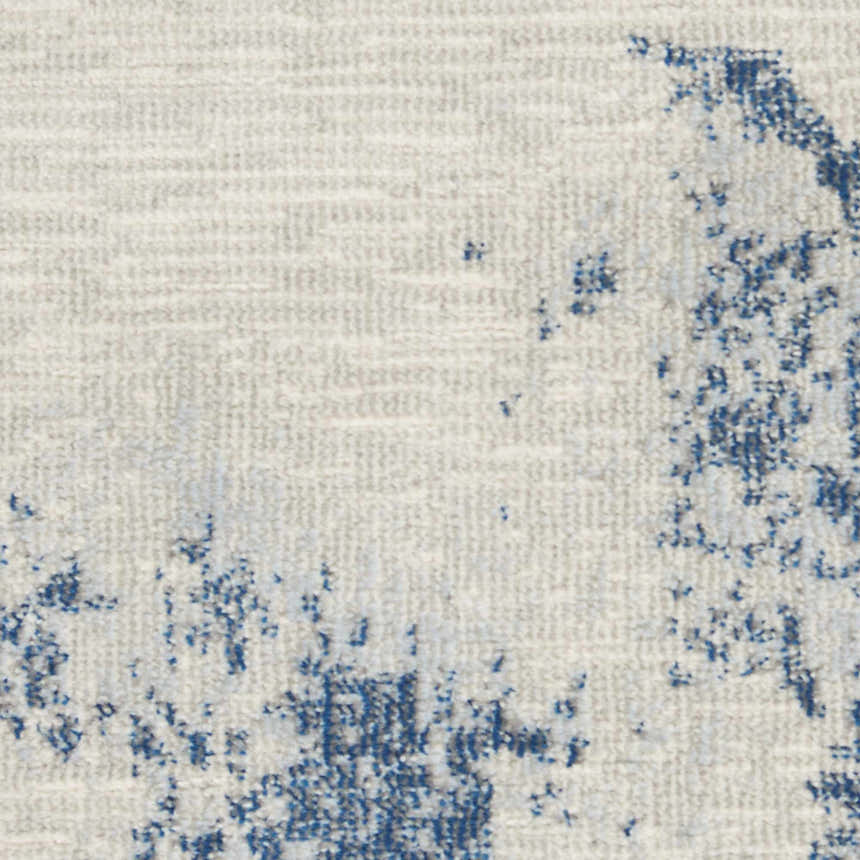 Close-up of the Nourison Etchings Ivory/Light Blue rug. Abstract pattern with blue accents on an ivory background.