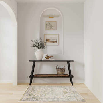 Entryway with black console table and Nourison Astra Blue Green Vintage Area Rug on light wood floors.