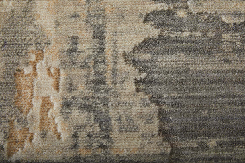 Close up of the Feizy Jaxson rug showing its gray, tan, and ivory abstract pattern and soft, textured wool blend. Texture