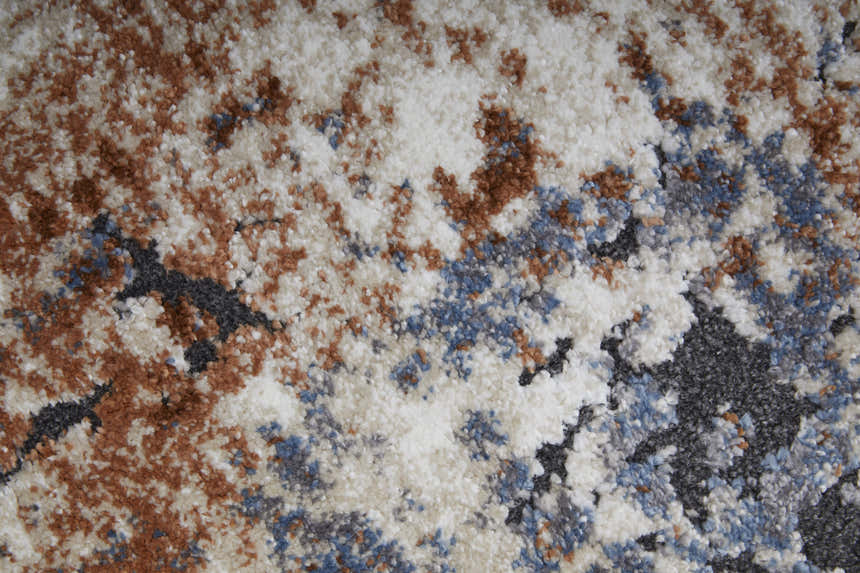 Close-up of the Feizy Gilmore rug. Distressed ivory rug with blue and taupe abstract pattern. Soft texture. Texture