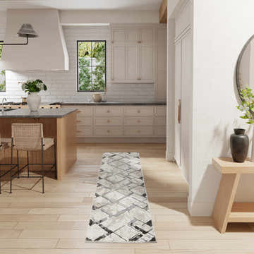 Modern kitchen with Nourison Glitz Ivory Grey rug, light wood floors, island, and neutral cabinets.