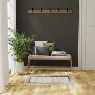 Entryway with bench, pillows, and Nourison Dekor Ivory Brown rug on wood floor.