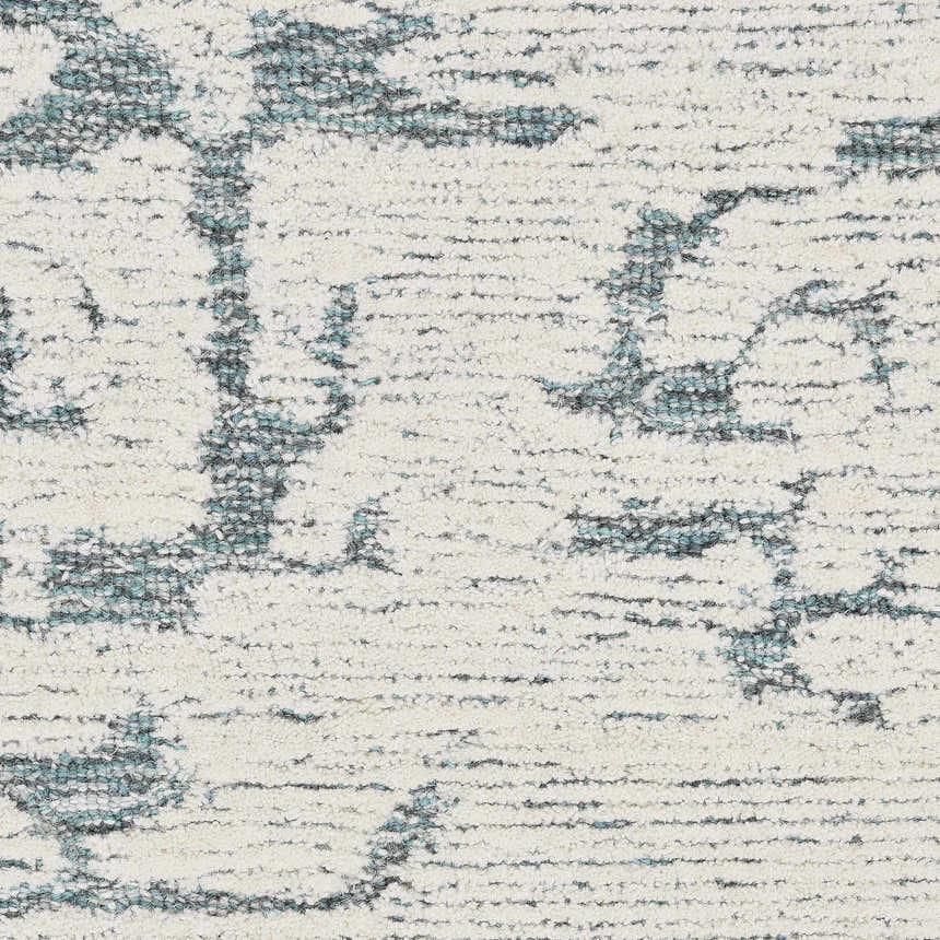Close-up of the Calvin Klein CK009 Sculptural Teal rug. Features a textured, abstract pattern in teal and ivory wool.