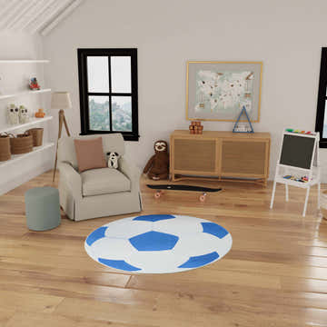 Kids room scene with a Nourison Imagination Blue Kids Indoor Washable Area Rug, soccer ball design, on hardwood floor.