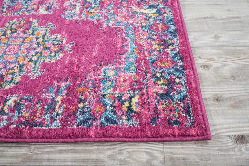 Close-up of the Nourison Passion Fuchsia rug. Features a bohemian pattern with fuchsia, blue, pink, and yellow colors.