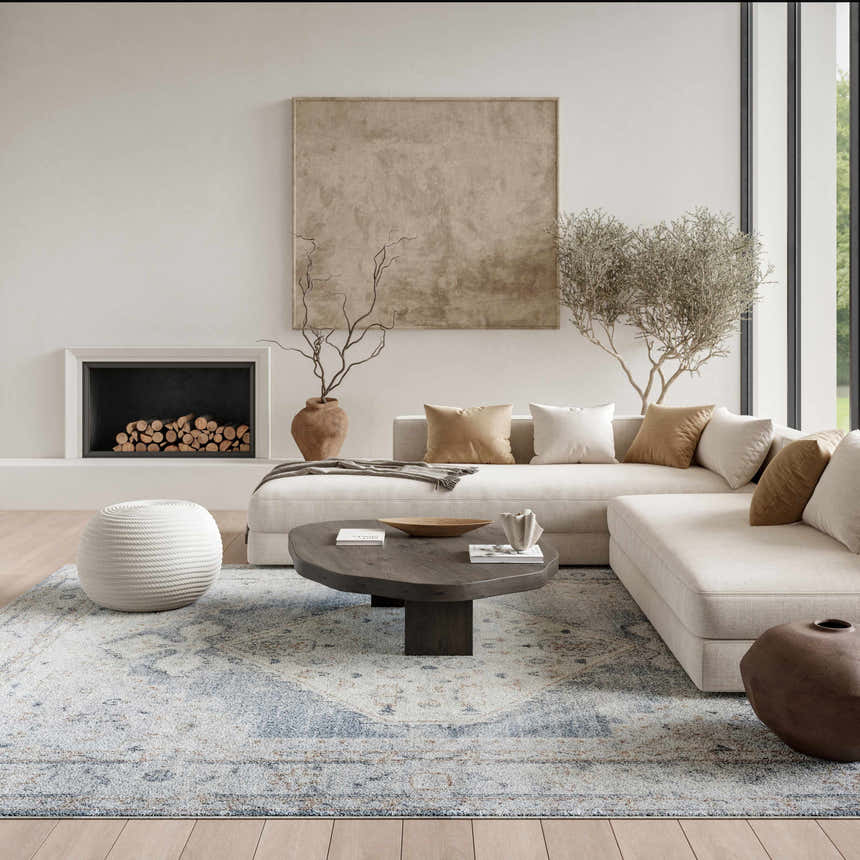 Living room scene with a Nourison Astra Light Blue Vintage rug, neutral sofa, fireplace, and wood accents.