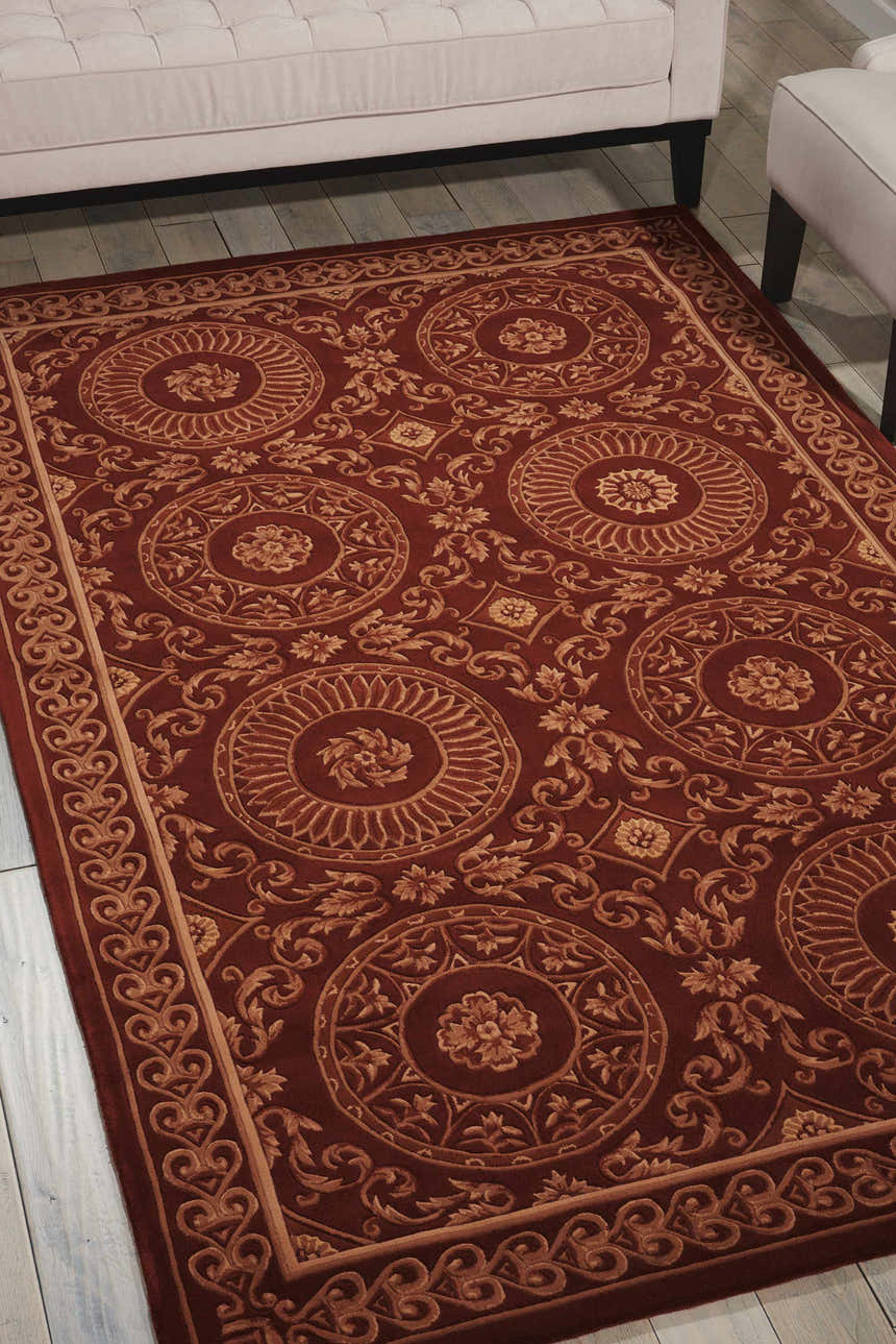Living room scene with a brick red Nourison Versailles Palace rug, cream sofa, and light wood floors.