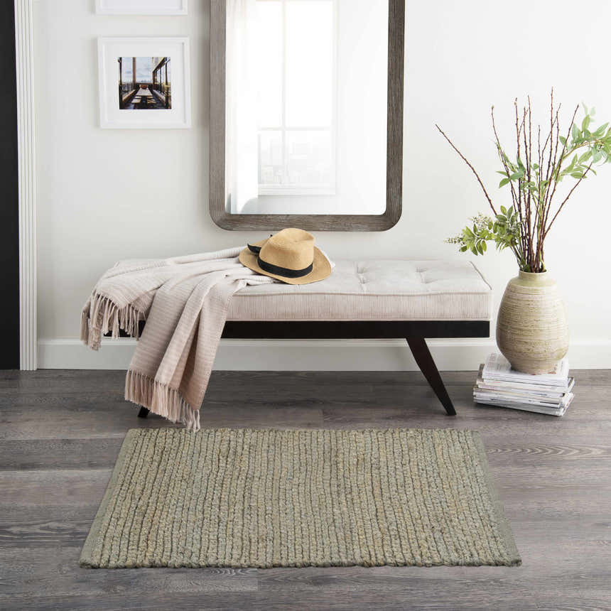 Entryway with bench, mirror, and Nourison Natural Jute Sage rug on gray wood floor. Farmhouse style.