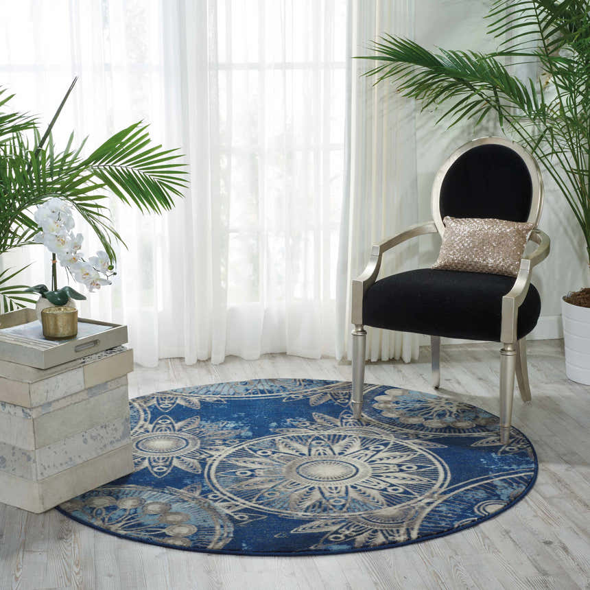 Living room scene with round Nourison Somerset Denim rug, black chair, and plants.