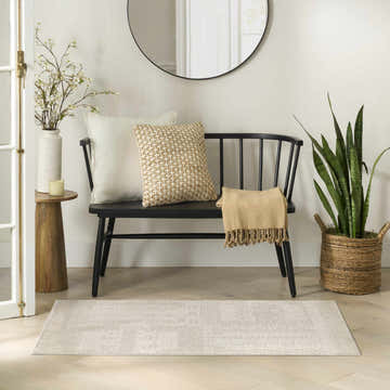 Entryway with black bench, round mirror, and Nourison Nordic Ivory rug runner on light wood floors.