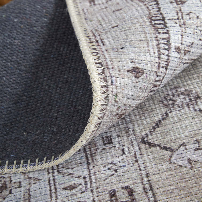 Close-up of Feizy Percy rug showing tan, ivory, and gray medallion pattern, texture, and machine-made construction. Fold