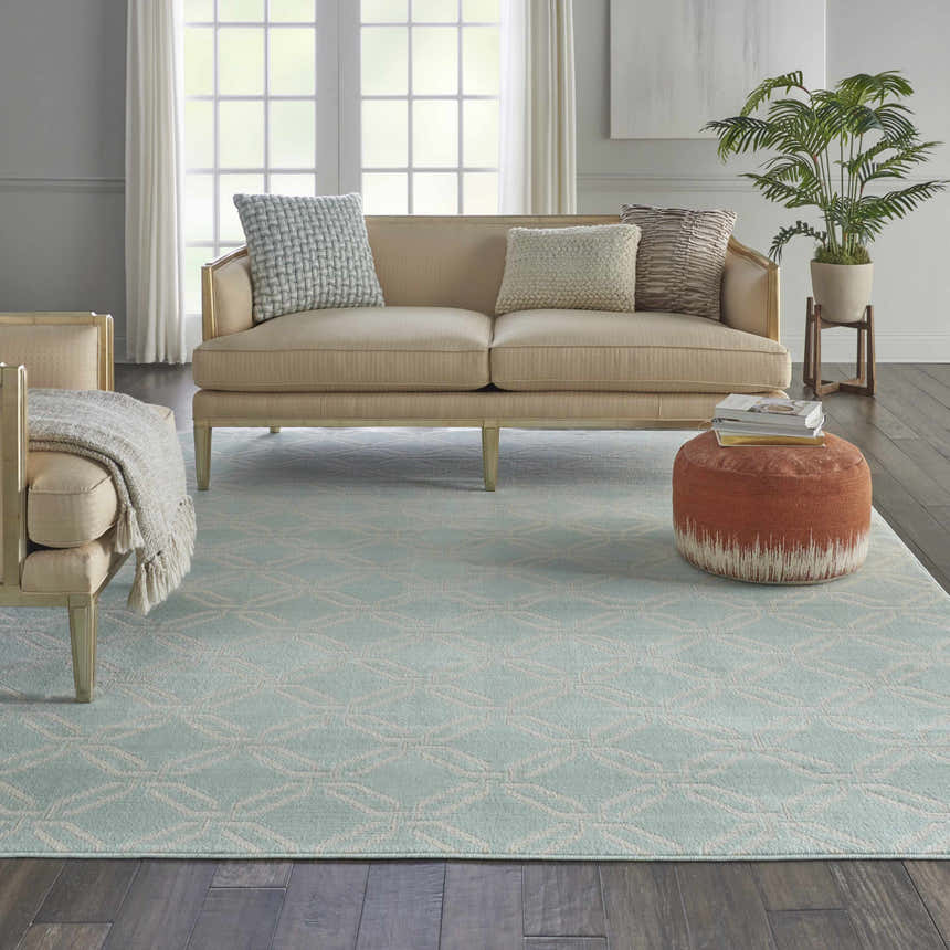 Living room scene with a light blue Nourison Jubilant Green rug, beige sofa, and dark wood floors. Coastal style.