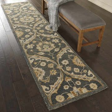 Entryway with Nourison Jazmine Navy Persian runner rug, wood floors, and bench with gray cushion.