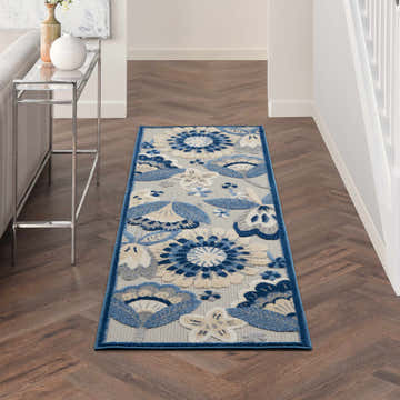 Hallway scene with Nourison Aloha Blue Grey rug runner, floral pattern, on wood floor. Console table with vases.