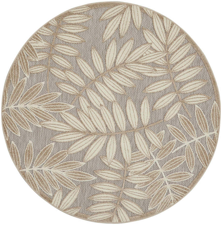 Close-up of round Nourison Aloha Natural Tropical Area Rug with a beige leaf pattern on a textured gray background.