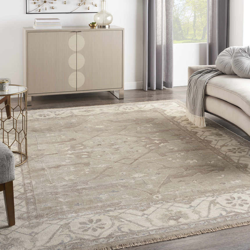 Living room scene with silver gray Nourison Aldora Vintage Area Rug, beige sofa, and light wood cabinet.