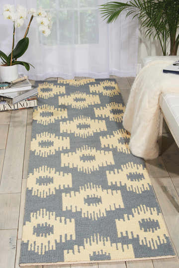 Living room scene with a taupe Barclay Butera Prism Slate runner rug, white sofa, and plants.