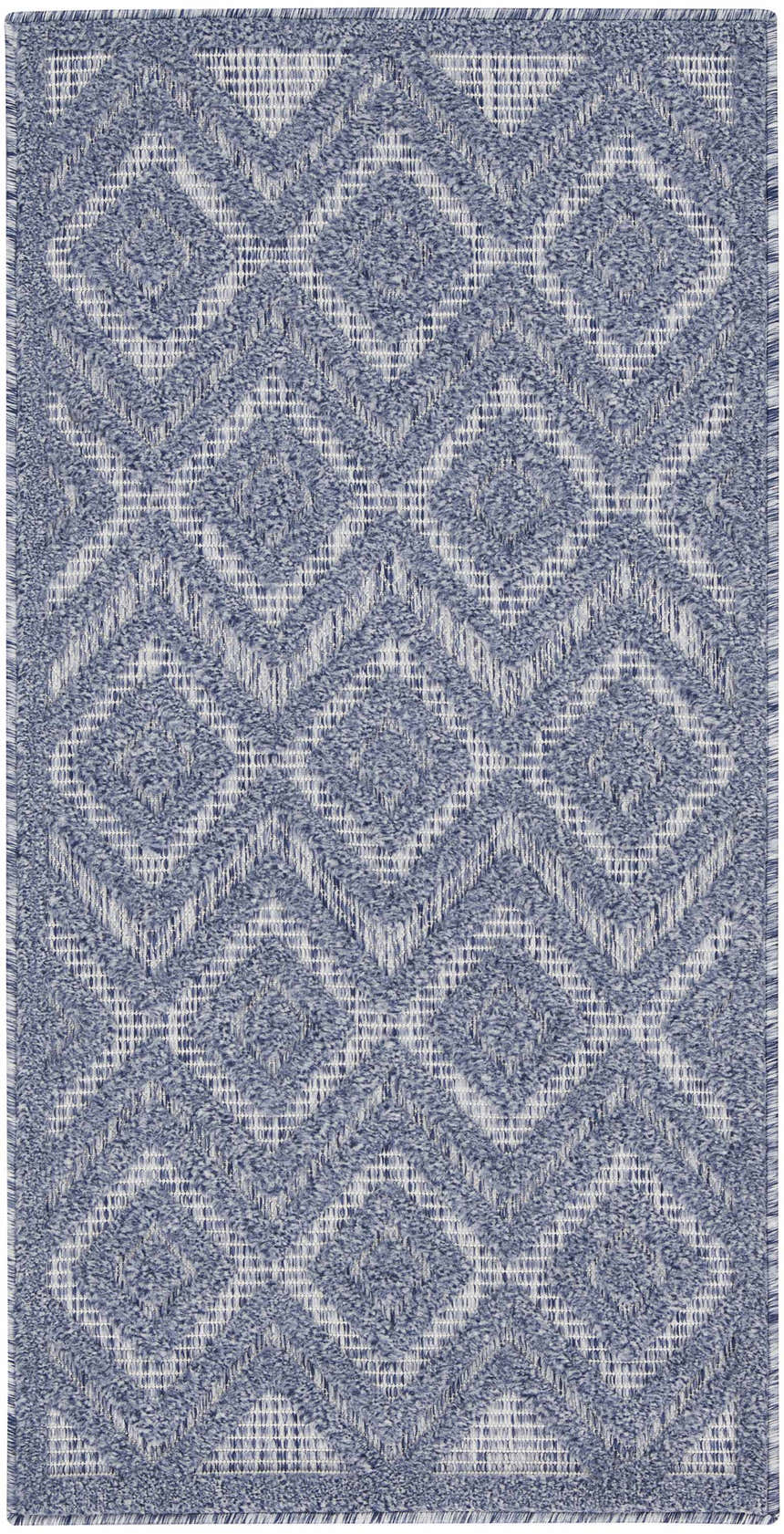 Close-up of the Nourison Versatile Denim Blue rug. Features a diamond pattern and woven texture in shades of denim and white.