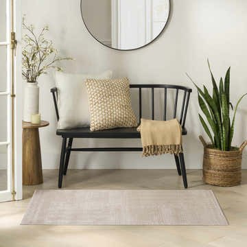 Entryway with a Nourison Nordic Taupe rug, black bench, round mirror, and wood accents for a modern, neutral look.