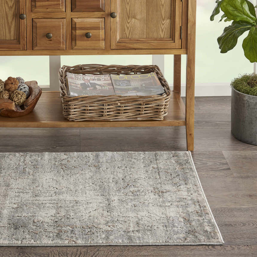 Entryway scene with Nourison Quarry Beige Gray rug, wood console table, and decor accents.