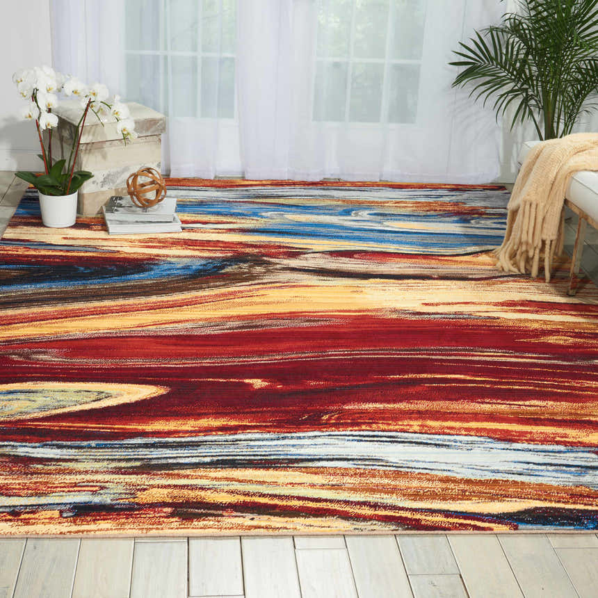 Bright living room with Nourison Chroma Lava Flow rug in red, blue, and gold abstract pattern.