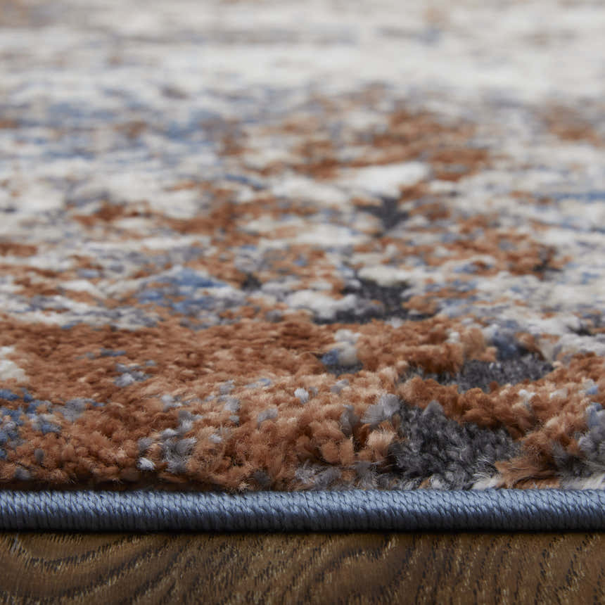 Close-up of the Feizy Gilmore Ivory/Blue/Taupe Rug showing its distressed pattern and textured weave. Pile