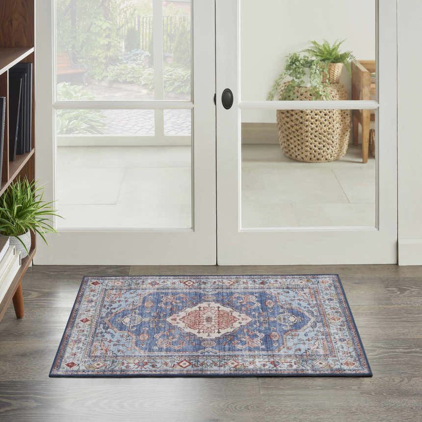 Entryway scene with a Nourison Fulton Blue Vintage Area Rug on wood floors near white french doors.