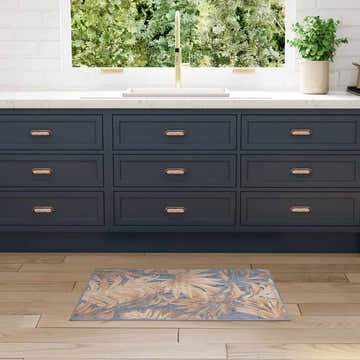 Kitchen scene with blue cabinets and the Nourison Aloha Blue Rose Modern Area Rug on wood floors.