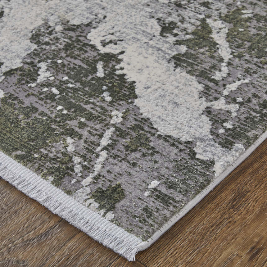 Close up of the Feizy Cadiz rug featuring a modern abstract design in gray, green, and taupe with fringe detail. Corner