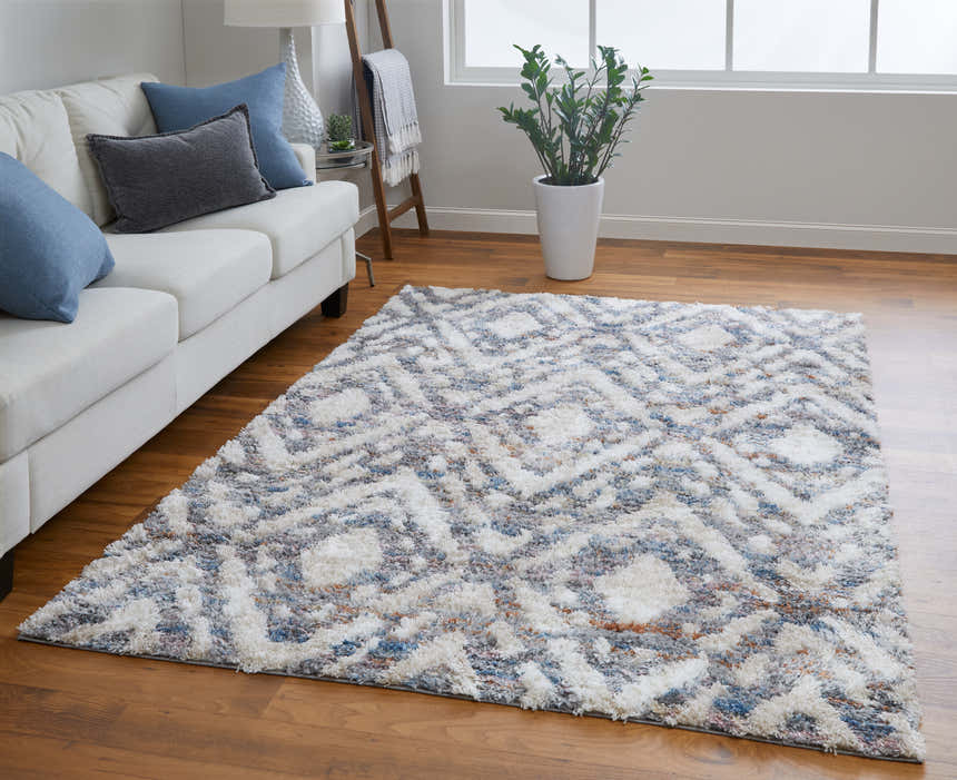 Living room scene with Feizy Mynka ivory, gray, and taupe rug, white sofa, wood floors, and natural light. Roomscene-Rectangle