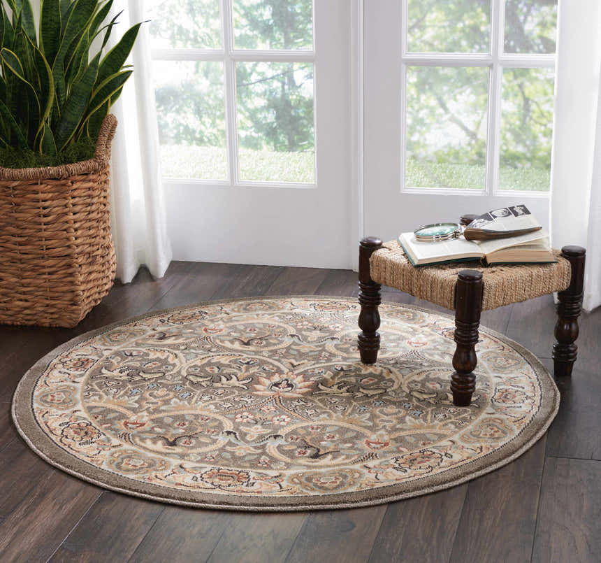 Bright room with a round Nourison Walden Grey rug, jute stool, and dark wood floors.