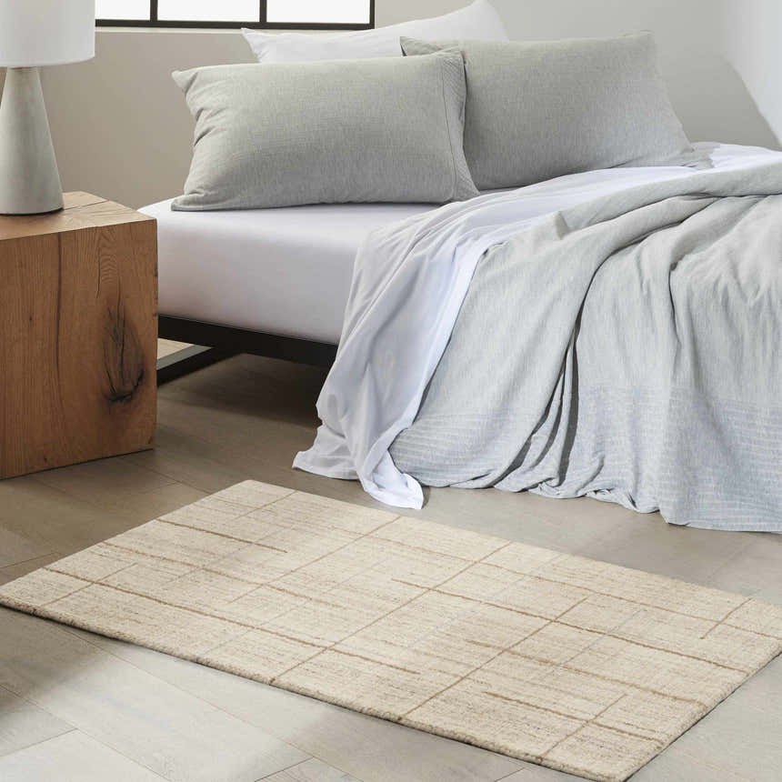 Bedroom scene with Calvin Klein CK041 Architectura Natural Farmhouse rug, wood nightstand, and gray bedding.