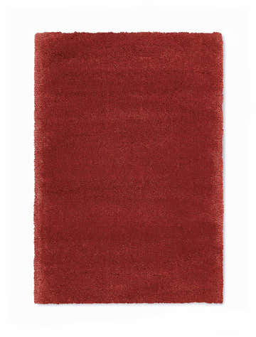 Close-up of a plush, burgundy Calvin Klein Brooklyn area rug. The rug has a shag texture and a rectangular shape.