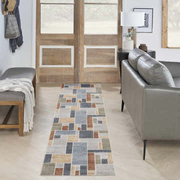Entryway with gray leather bench and Nourison Astra Multicolor rug runner with geometric pattern.