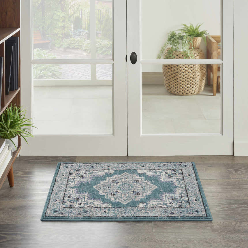 Entryway scene with Nourison Passion Turquoise Grey rug, white french doors, and wood floors.