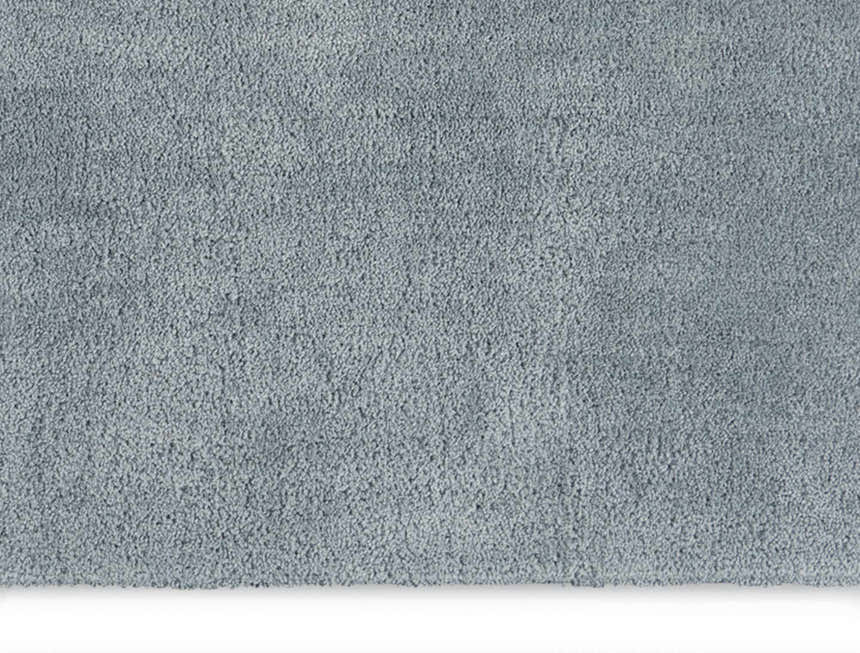 Close-up of the Calvin Klein Chicago Shag rug. The grey shag texture is soft and plush. Modern style.