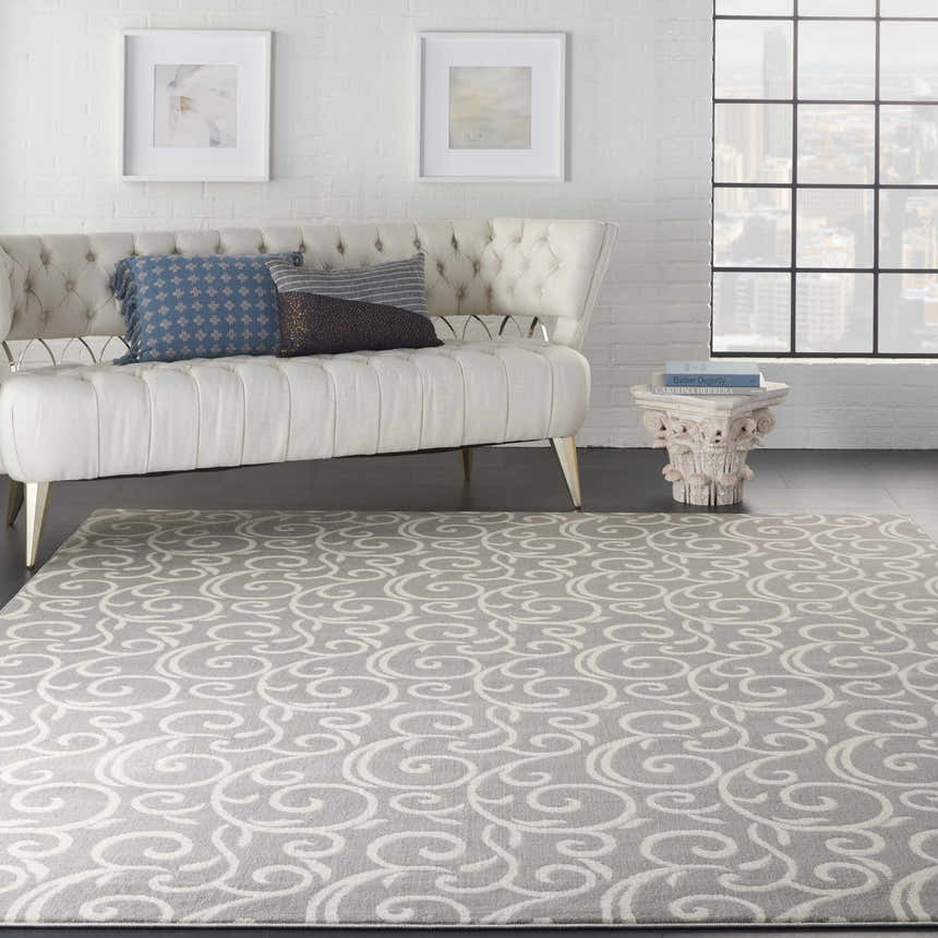 Living room with a tufted sofa and Nourison Grafix Grey Contemporary Area Rug with a swirling pattern.