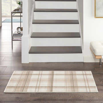 Entryway scene with a Nourison Grafix Ivory Beige rug, farmhouse style, with a plaid pattern on dark wood floors.