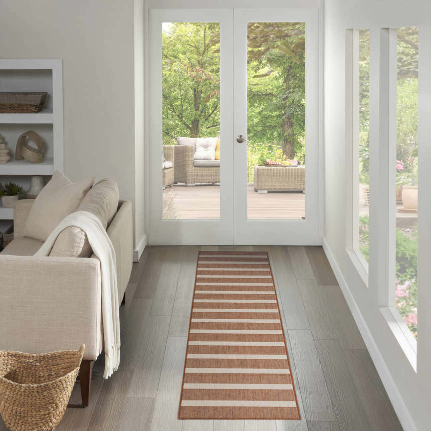 Hallway with a Nourison Positano Terracotta Ivory rug runner leading to an outdoor patio. Neutral tones, light and airy.