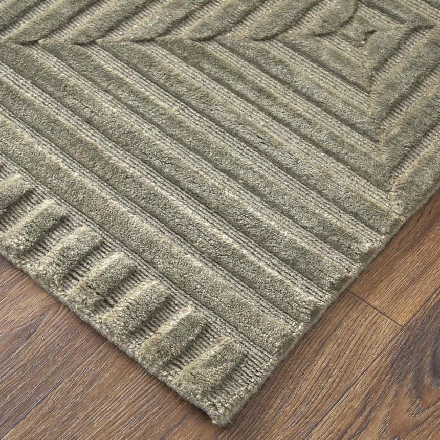 Close up of Feizy Channels Modern Geometric rug in green and taupe, showing textured wool and linear pattern. Corner