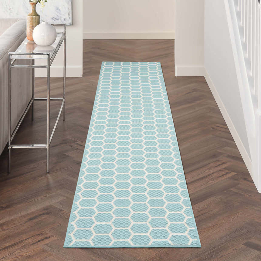 Hallway with Nourison Twist Reversible Aqua Modern Area Rug runner on dark wood floors. Console table with vases.