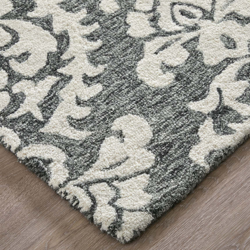 Close-up of Feizy Belfort rug. Gray and ivory floral pattern, hand-tufted wool texture. Corner