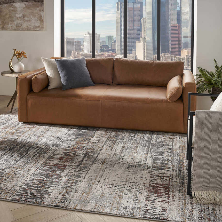 Modern living room with brown leather sofa and Nourison Tangra Multicolor Area Rug. City view.
