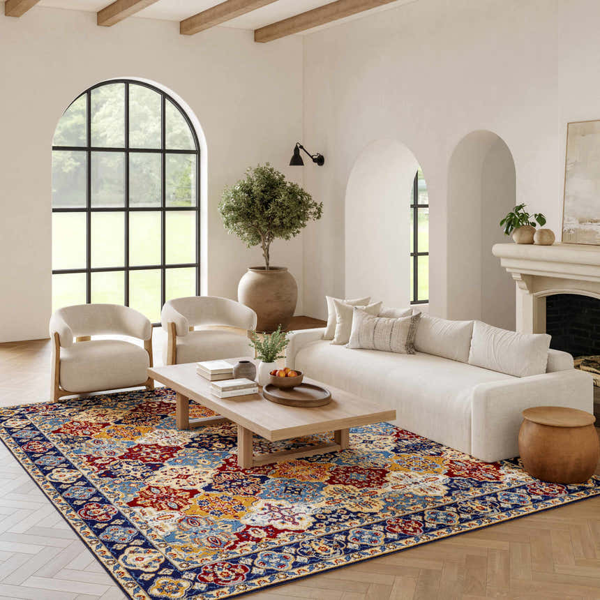 Living room with a Nourison Grafix Multicolor Bohemian rug, cream sofa and chairs, wood floors, and arched windows.