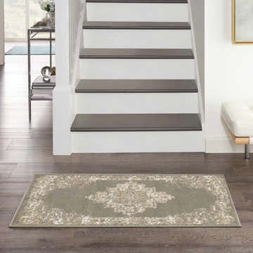 Entryway with stairs and olive Nourison Grafix vintage rug on dark wood floor.