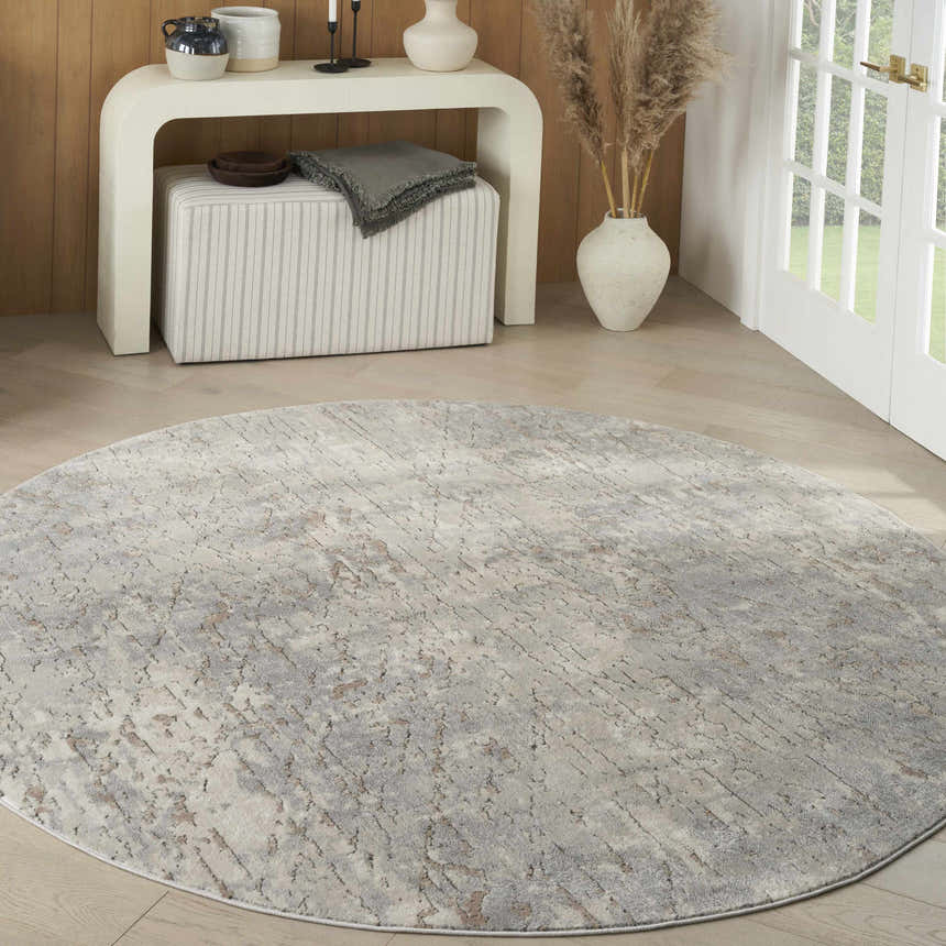 Modern living room scene with a round Nourison Quarry Beige Gray area rug.