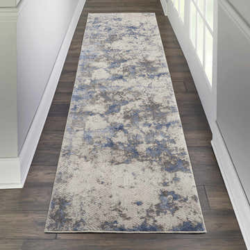 Hallway with Nourison Silky Textures Blue Ivory Grey rug runner on dark wood floor. Modern abstract design.