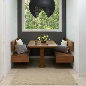 Breakfast nook with wood benches and a Nourison Tulum Taupe Outdoor Area Rug.