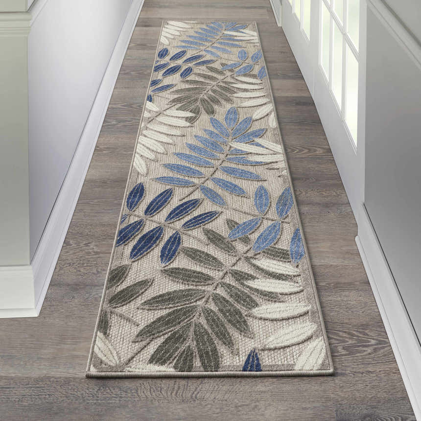 Hallway with Nourison Aloha Grey Blue Tropical Area Rug runner, wood floors, and white trim.