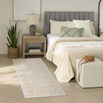 Farmhouse bedroom scene with a Nourison Botanical Beige Multicolor area rug, wood floors, and neutral decor.